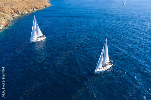 Sailing boats with white sails, rippled sea background © Rawf8