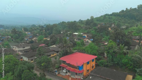 Dolly forward drone shot over rural Indian village on hillside photo