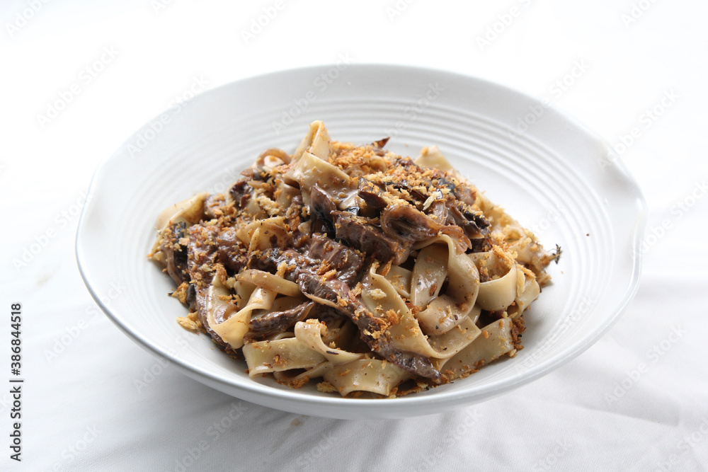 Pasta fettucine with mushrooms and creamy pesto sauce . Traditional italian food. Pasta with champignons, pesto and thyme. Copy space, side view Pasta fettucine with mushrooms and creamy pesto sauce . Traditional italian food. Pasta with champignons, pesto and thyme. Copy space, side view