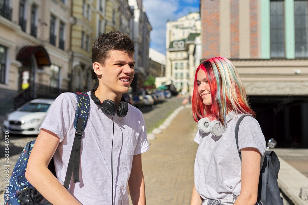 Portrait of talking students teenagers boy and girl 16, 17 years old in the city