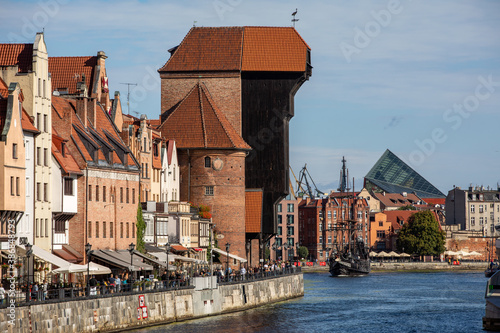  The largest medieval port Crane in Europe and historic buildings on the Dlugie Pobrzeze over the Motlawa River in Gdansk, Poland.