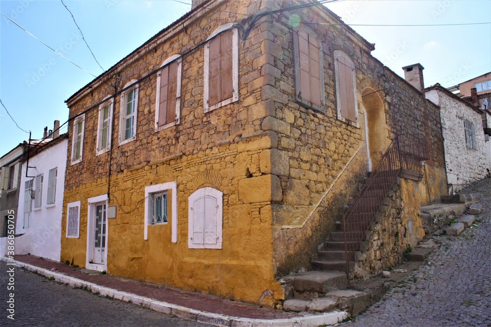 Vintage and yellow house in Turkey. Ancient yellow and stone house in Izmir, Turkey. Vintage house on cobbled stone street