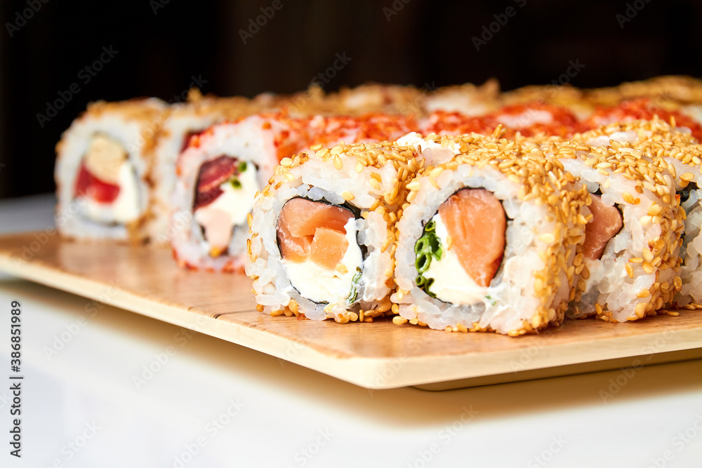 Set of various sushi rolls on a board. Close-up, selective focus