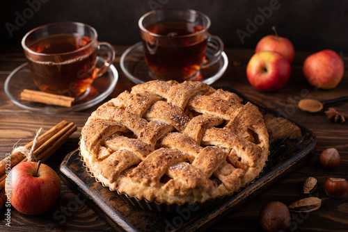 apple pie with cinnamon and hot black tea in glass cup