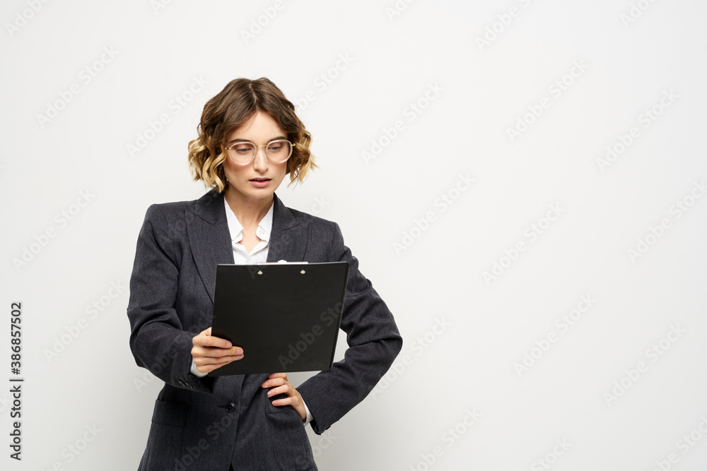 business woman in a suit with documents in hands light background curly hair hairstyle business woman in a suit with documents in hands light background curly hair hairstyle