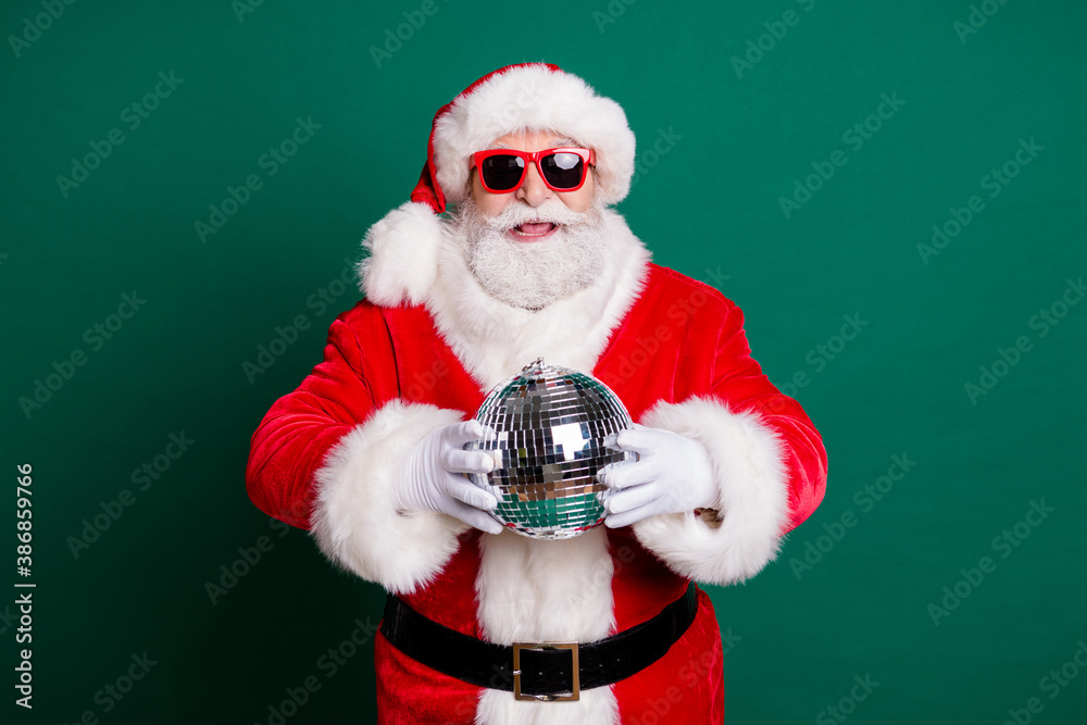 Portrait of his he nice attractive handsome cheerful Santa grandfather mc pj father having fun holding in hands silver glossy ball newyear celebratory good mood isolated over green color background - obrazy, fototapety, plakaty 