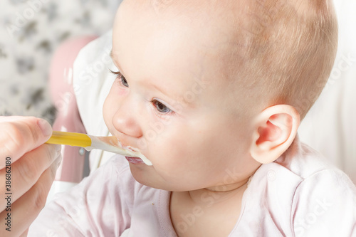 Child girl eating food with a spoon