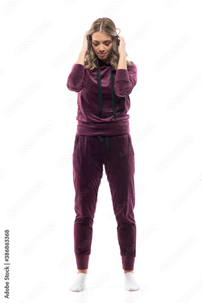 Beautiful girl in domestic homewear clothes wearing socks touching hair looking down relaxed. Full body isolated on white background. Beautiful girl in domestic homewear clothes wearing socks touching hair looking down relaxed. Full body isolated on white background.