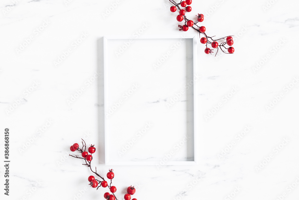 Christmas composition. Red berries, photo frame on marble background. Christmas, winter, new year concept. Flat lay, top view - obrazy, fototapety, plakaty 