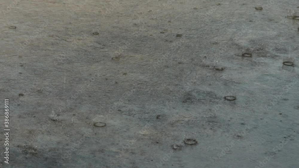 heavy rain drops falling on the cement ground. It's raining on the mortar floor. heavy rain drops falling on the cement ground. It's raining on the mortar floor.