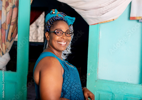 beautiful adult woman standing in front of her house smiling