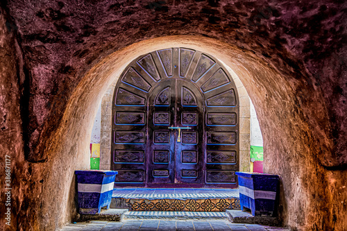 Beautifully carved arched wooden door under the arch in the alley of Medina. Essaouria , Morocco. photo