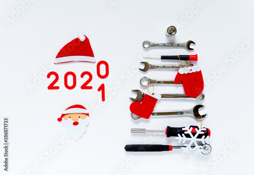 New Year tree made of construction tools with decorations and numbers 2020-2021 on a white background. New Year concept for car workshop and construction company