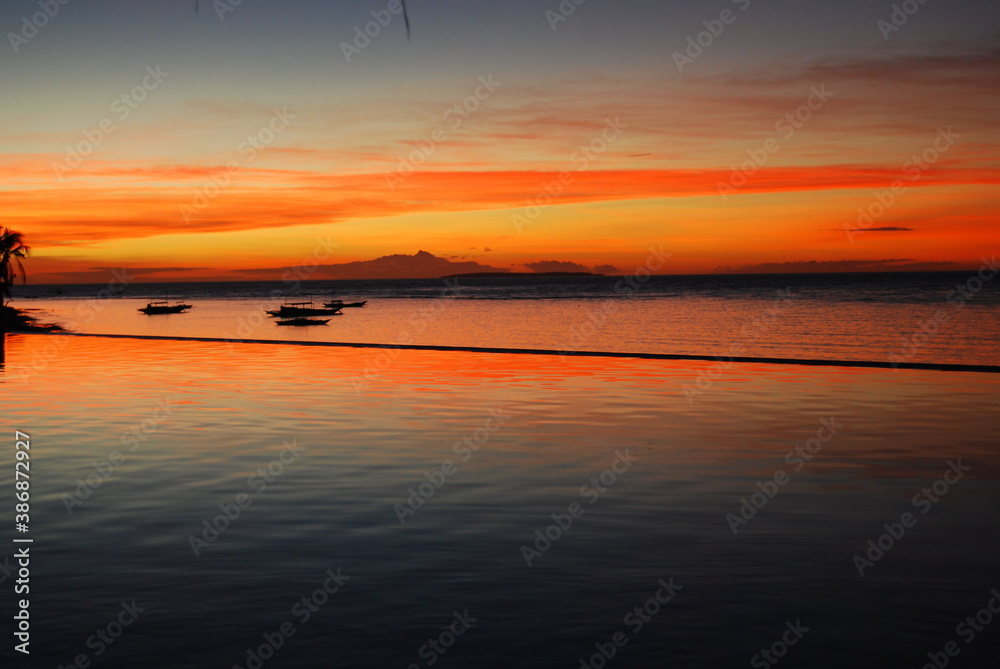 panoramic red sunset over the sea on tropical island with beautiful sky reflection in the water