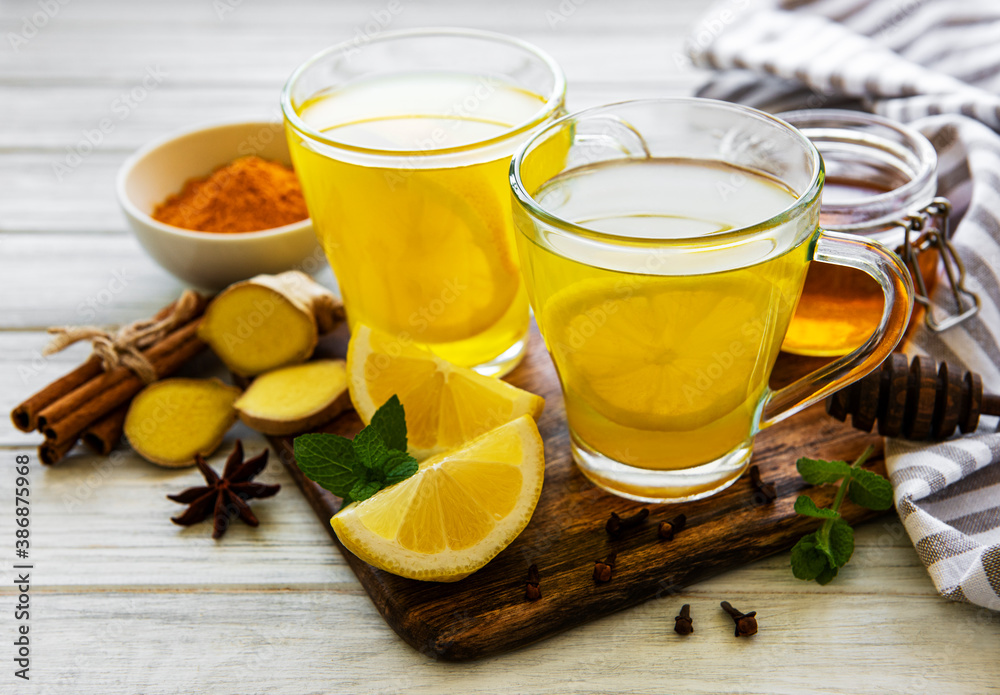 Energy tonic drink with turmeric, ginger, lemon and honey on a white wooden background - obrazy, fototapety, plakaty 