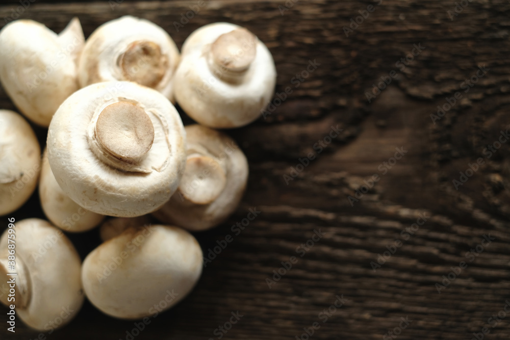 Fresh champignon mushrooms on wooden table, closeup. Space for text