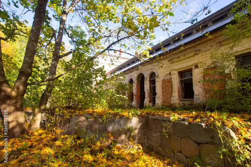 Old ruined historical house in golden autumn fall park