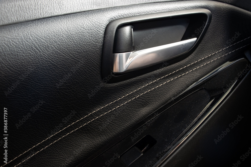 Car door handle inside, closeup view. Interior of modern car with door handle.