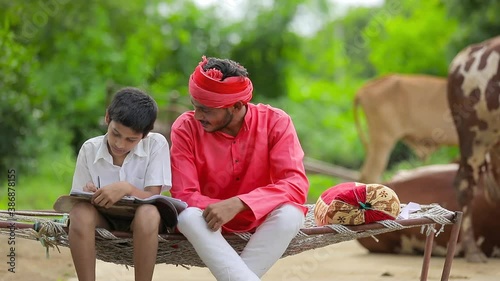 Cute Indian child studying with his father at home