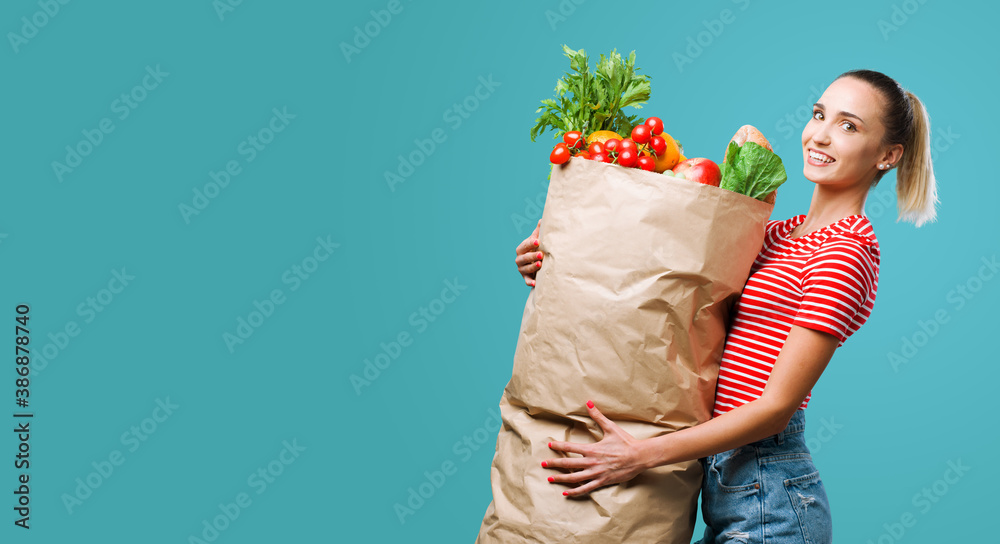 Εκτύπωση καμβά Cheerful woman holding a huge grocery shopping bag