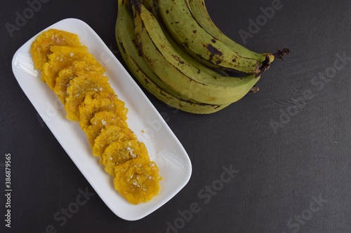 Fried Green Plantains or Tostones on black background photo