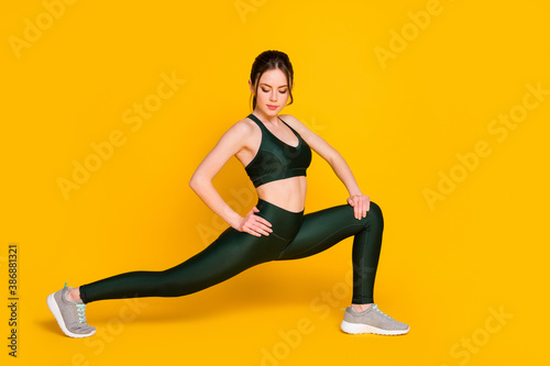 Fototapeta Naklejka Na Ścianę i Meble -  Profile photo of sportive lady make stretching split legs wear sports suit pants sneakers isolated yellow color background