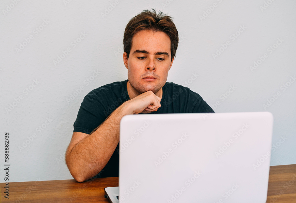 Young Caucasian Redhead Guy Looking Concentrate to Laptop Screen Young Caucasian Redhead Guy Looking Concentrate to Laptop Screen