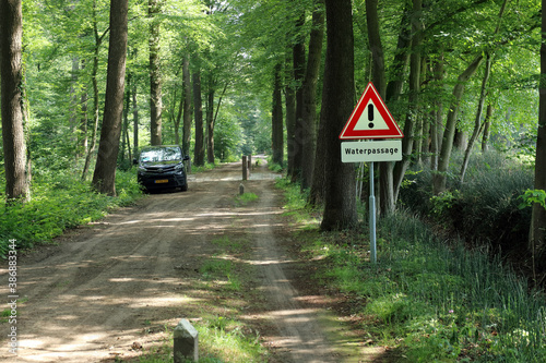 Warning sign for a ford in a rural forest road near Winterswijk, Netherlands photo