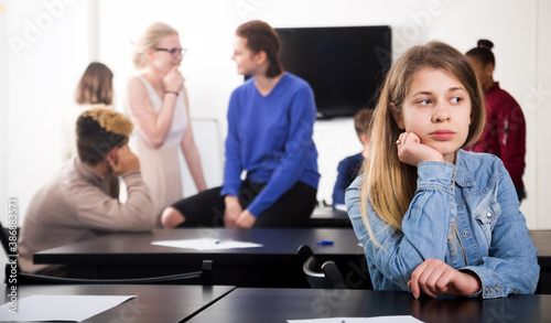 Картината върху платно Beautiful new girl student being shy among classmates at recess in school