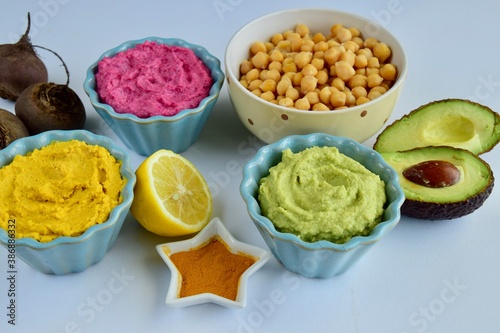 Assorted colorful hummus, healthy vegan dips. Traditional Middle eastern. Avocado hummus, Beetroot hummus, Turmeric hummus