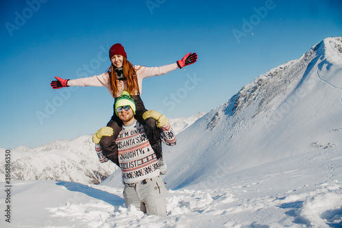 A loving couple in the winter in the mountains. Husband and wife rejoice in the snow.