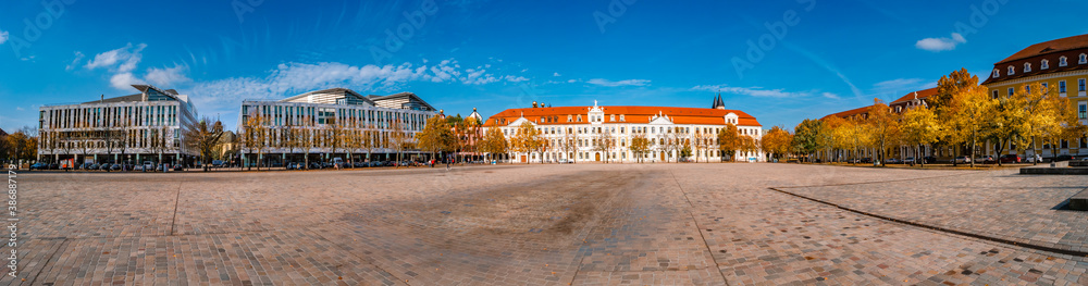Panoramic view of major Dome square with fountains by Cathedral and Government Office in Magdeburg, Germany, at sunny day and blue sky during Golden Autumn. Panoramic view of major Dome square with fountains by Cathedral and Government Office in Magdeburg, Germany, at sunny day and blue sky during Golden Autumn.