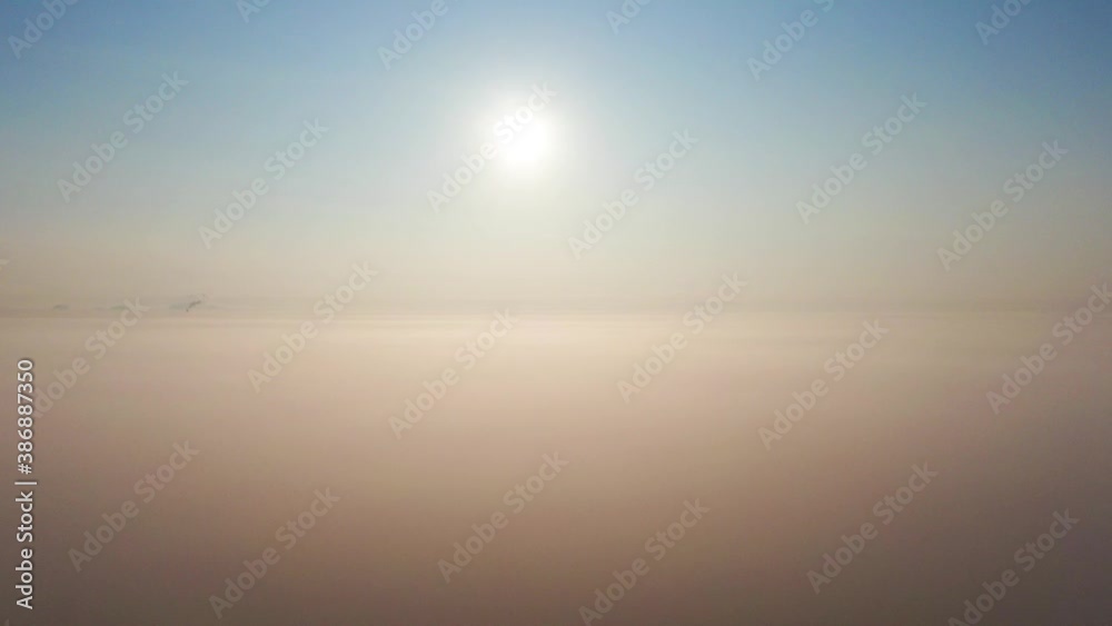 Aerial view of the city in the fog in the haze of clouds. Emissions into the atmosphere from industrial pipes. Aerial view of the city in the fog in the haze of clouds. Emissions into the atmosphere from industrial pipes.