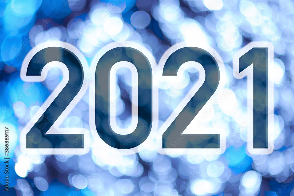 Text with the number of the year 2021 with a background of bright lights out of focus in blue tones. Happy New Year 2021. Text with the number of the year 2021 with a background of bright lights out of focus in blue tones. Happy New Year 2021.