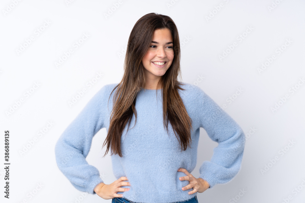 Teenager girl over isolated white background posing with arms at hip and smiling Teenager girl over isolated white background posing with arms at hip and smiling