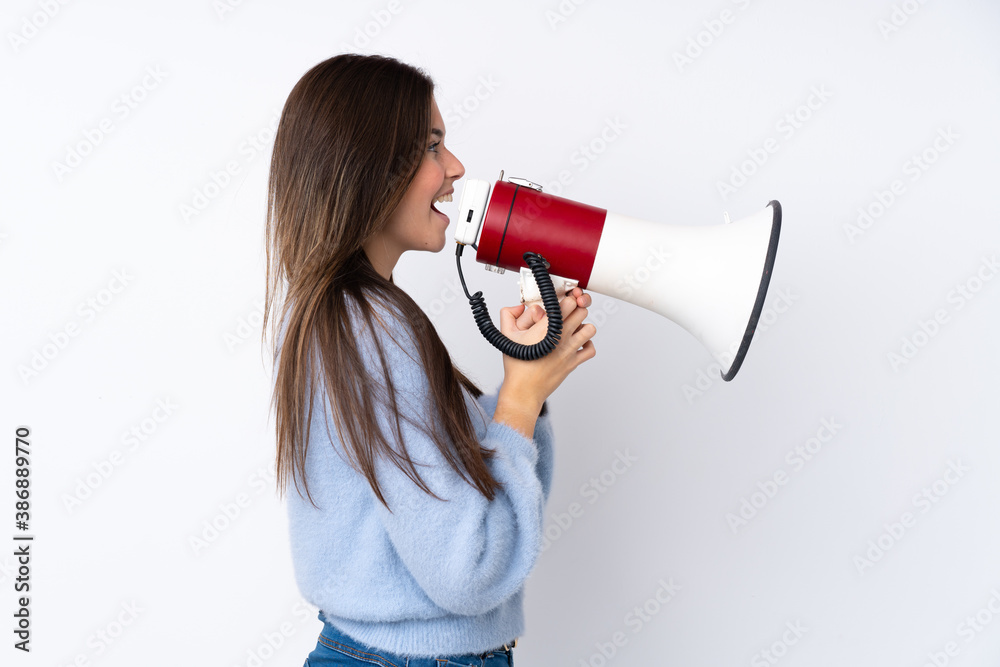 Teenager girl over isolated white background shouting through a megaphone
