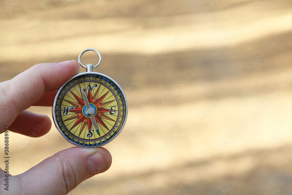 Old classic navigation compass in hand on natural background as symbol of tourism with compass, travel with compass and outdoor activities with compass Old classic navigation compass in hand on natural background as symbol of tourism with compass, travel with compass and outdoor activities with compass