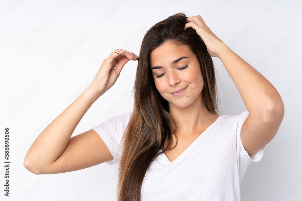 Teenager girl over isolated background with hair comb Teenager girl over isolated background with hair comb