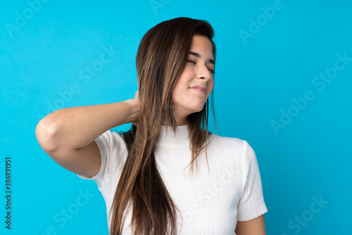Teenager girl over isolated blue background with neckache
