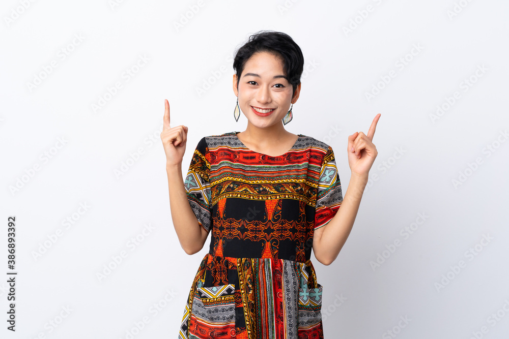 Young Asian girl with a colorful dress over isolated white background pointing up a great idea Young Asian girl with a colorful dress over isolated white background pointing up a great idea