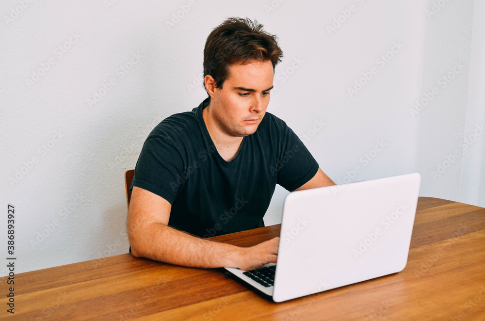 Young Redhead Flabby Guy Working Concentrate on his Laptop at Home Office Young Redhead Flabby Guy Working Concentrate on his Laptop at Home Office