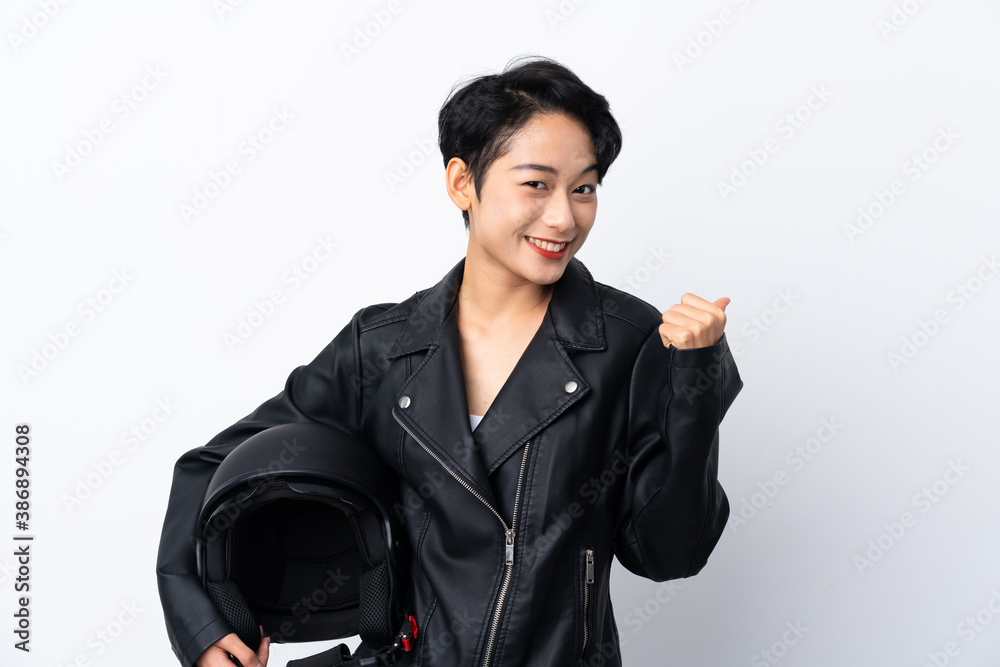 Young Asian girl with a motorcycle helmet over isolated white background pointing to the side to present a product Young Asian girl with a motorcycle helmet over isolated white background pointing to the side to present a product