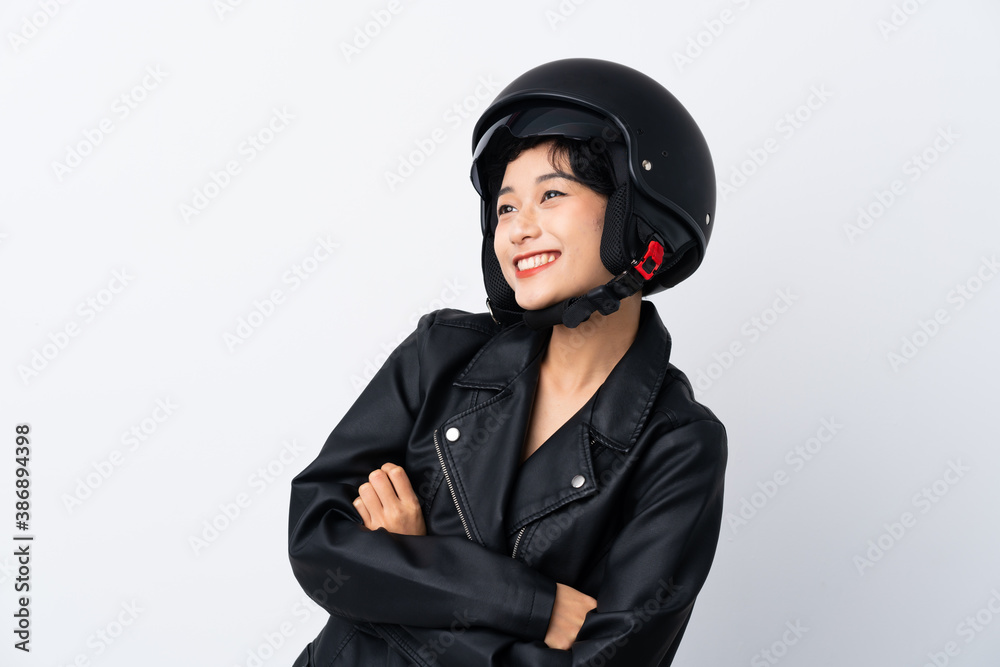 Young Asian girl with a motorcycle helmet over isolated white background Young Asian girl with a motorcycle helmet over isolated white background