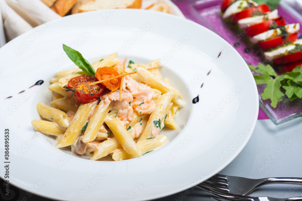 Traditional Italian pasta penne with salmon and creamy sauce. Traditional Italian pasta penne with salmon and creamy sauce.