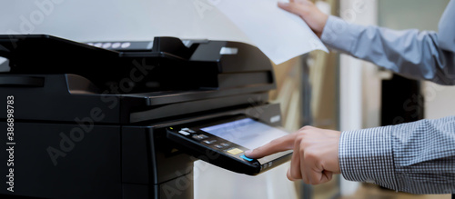 Business man Hand press button on panel of printer, printer scanner laser office copy machine supplies start