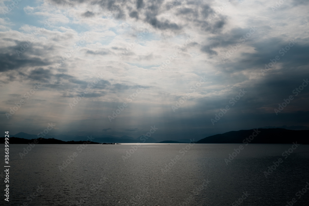 Sun rays over the sea with view across to Skye from Loch Carron, Scotland