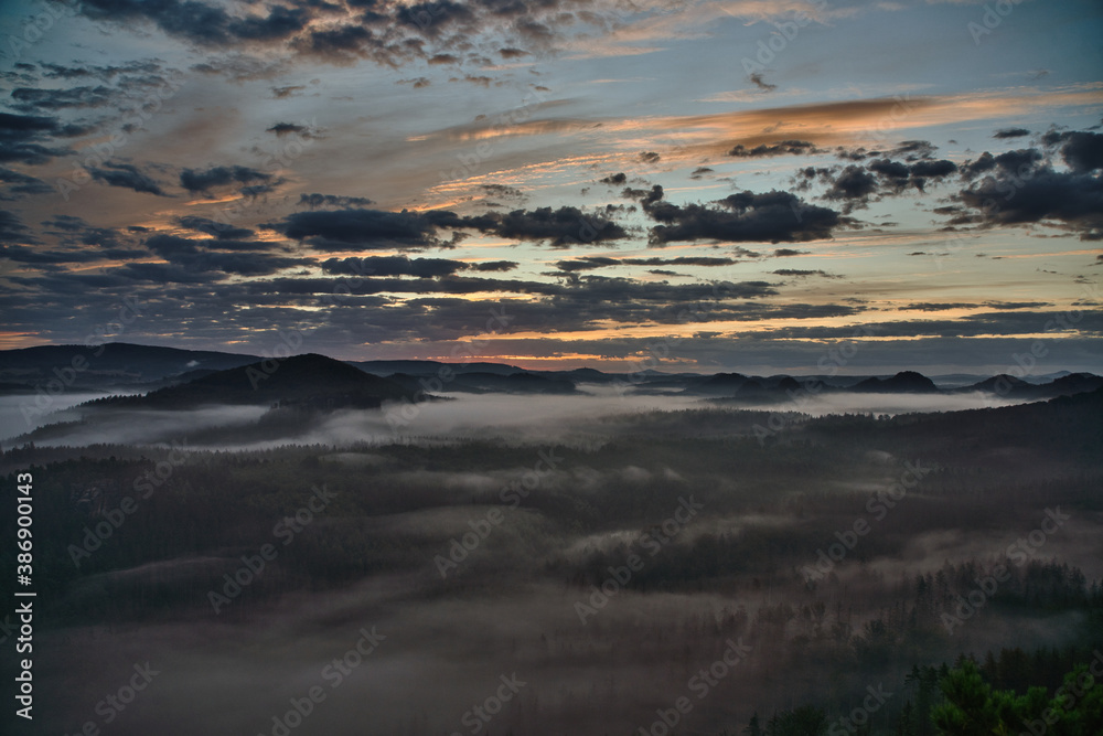 Panoramablick in den Morgenstunden von den Affensteinen zum Kleinen Winterberg. Die Sonne schickt ihre wärmenden Strahlen durch den dichten Nebel in die Bergwelt des Nationalparkes Sächsische Schweiz