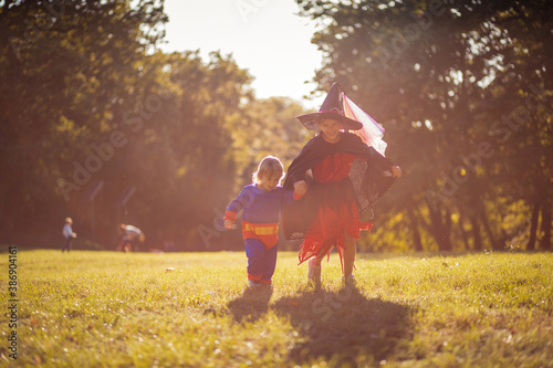  Two kids in Halloween suits standing in the park. © liderina