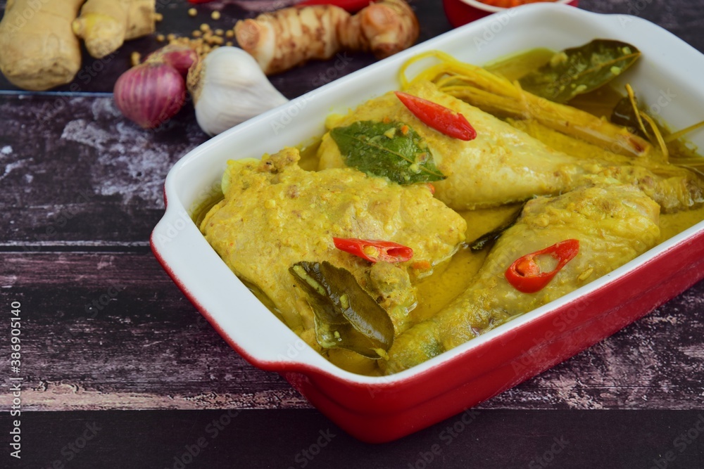 Opor ayam, chicken cooked in coconut milk and spices, originated from Central Java, Indonesia. Served with sambal. Popular dish for lebaran or Eid al-Fitr Opor ayam, chicken cooked in coconut milk and spices, originated from Central Java, Indonesia. Served with sambal. Popular dish for lebaran or Eid al-Fitr