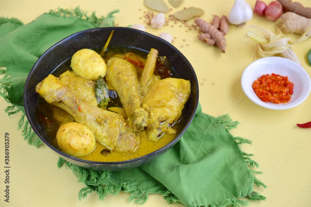 Opor ayam, chicken cooked in coconut milk added with boiled eggs. Originated from Central Java, Indonesia, served with sambal. Popular dish for lebaran or Eid al-Fitr Opor ayam, chicken cooked in coconut milk added with boiled eggs. Originated from Central Java, Indonesia, served with sambal. Popular dish for lebaran or Eid al-Fitr